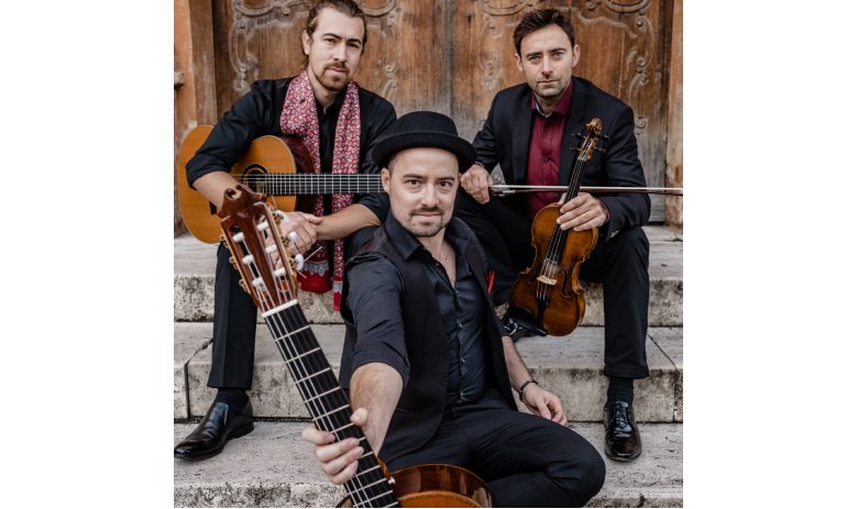 Bandfoto von Cobario - drei Personen in Anzügen sitzen auf einer Treppe, alle halten ein anderes Saiteninstrument: zwei Gitarren und eine Geige.