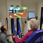 Une personne assise sur un fauteuil interagit avec un écran